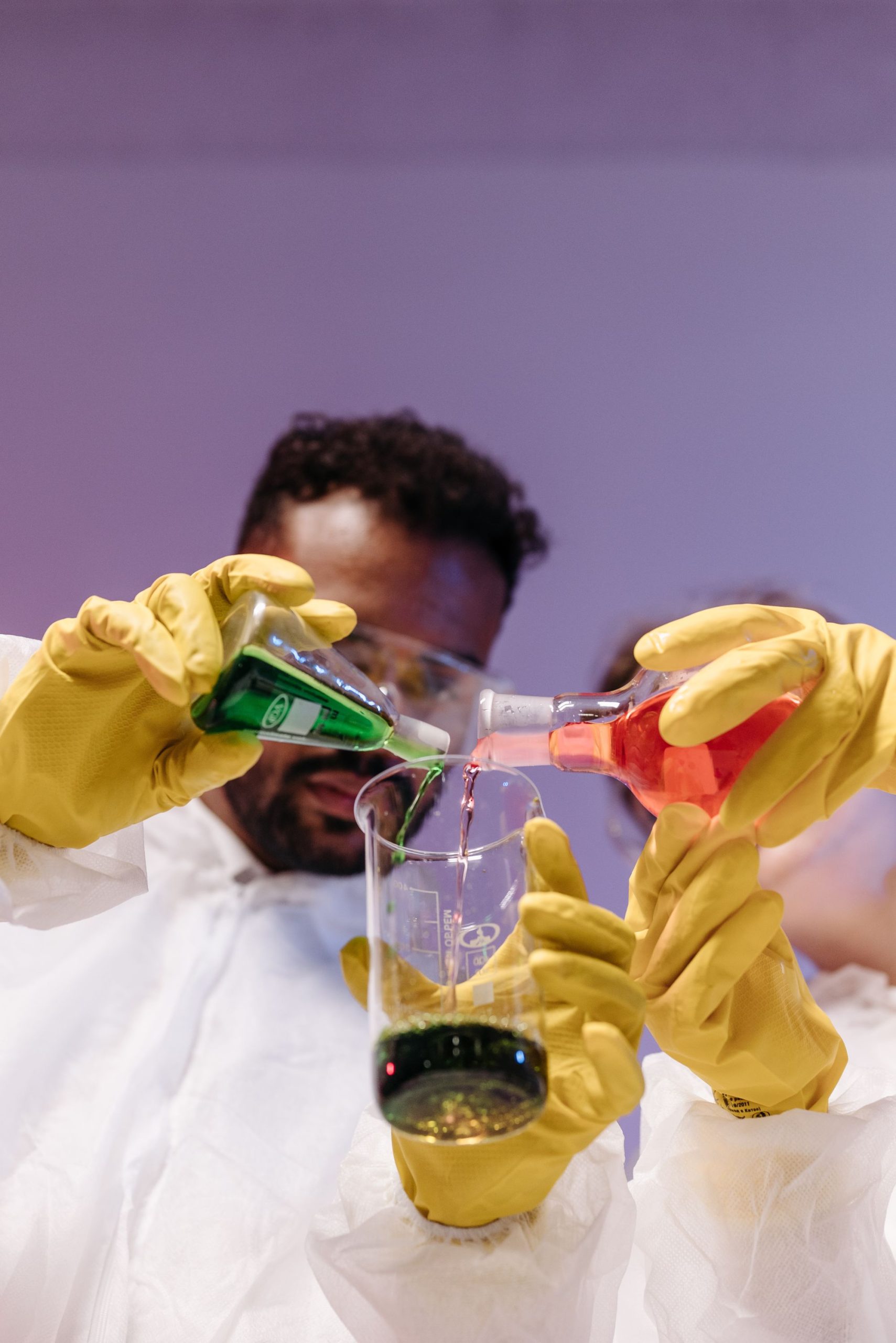 Laboratory technician mixing colored liquids for chemical quality control
