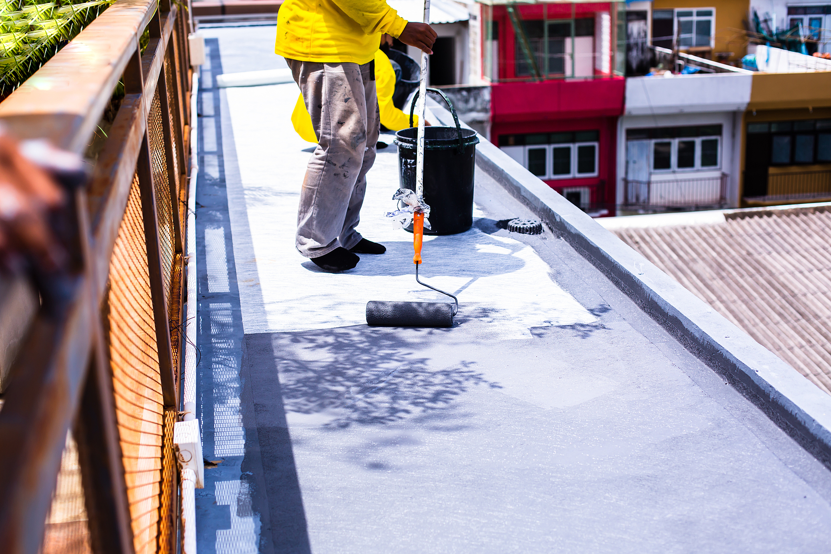 Roof waterproofing coating application scene.