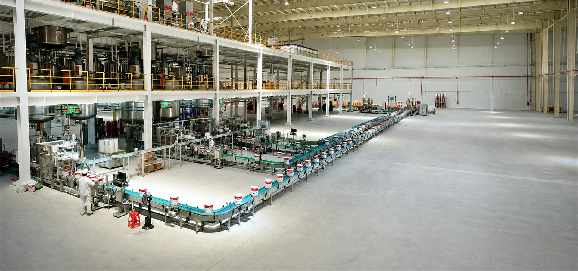 Interior production-line scene in a coatings manufacturing factory.